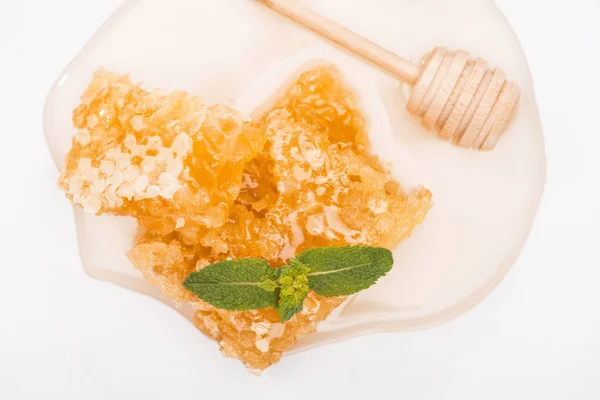 Close up vista de favo de mel com mel decorado com hortelã perto de mel de madeira dipper no fundo branco — Fotografia de Stock