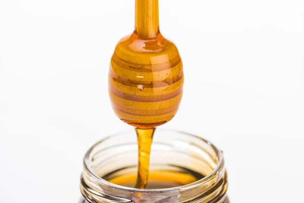 Honiglöffel aus Holz mit tropfendem Honig isoliert auf weiß — Stockfoto