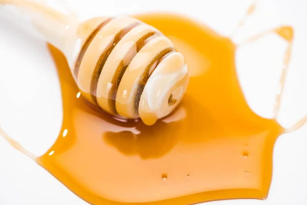 Charco de miel y tarro de miel de madera aislado en blanco - foto de stock