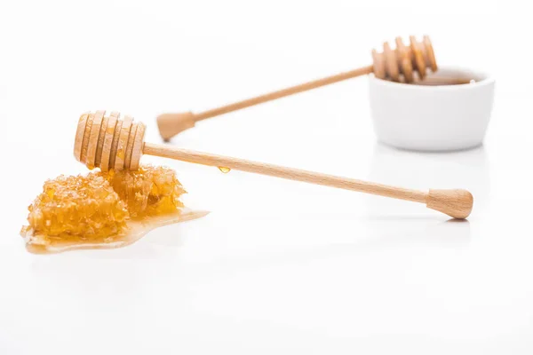 Selective focus of honeycomb with sweet honey and wooden honey dippers isolated on white — Stock Photo