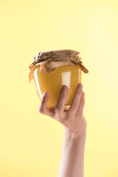 Vista ritagliata di donna con vaso di vetro con delizioso miele isolato su giallo — Foto stock