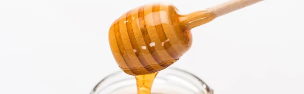 Tiro panorâmico de mel de madeira mergulhador com gotejamento delicioso mel isolado no branco — Fotografia de Stock