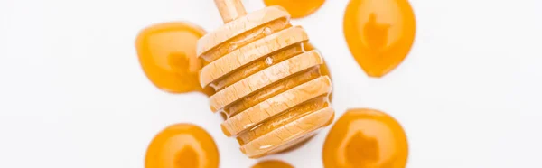 Plano panorámico de gotas de miel y tarro de miel de madera aislado en blanco - foto de stock