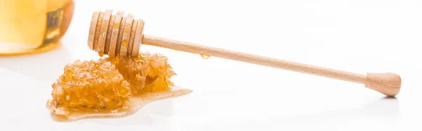 Tiro panorâmico de favo de mel com mel doce e mel de madeira mergulhador perto jar isolado em branco — Fotografia de Stock