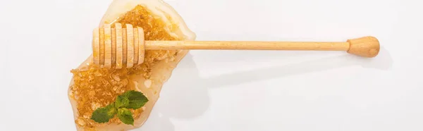 Panoramic shot of honeycomb with sweet honey, mint and wooden honey dipper on white — Stock Photo