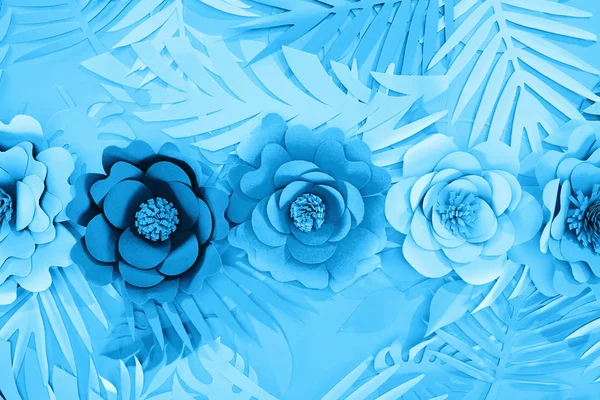 Leigos planos com folhas de corte de papel e flores em fundo azul — Fotografia de Stock