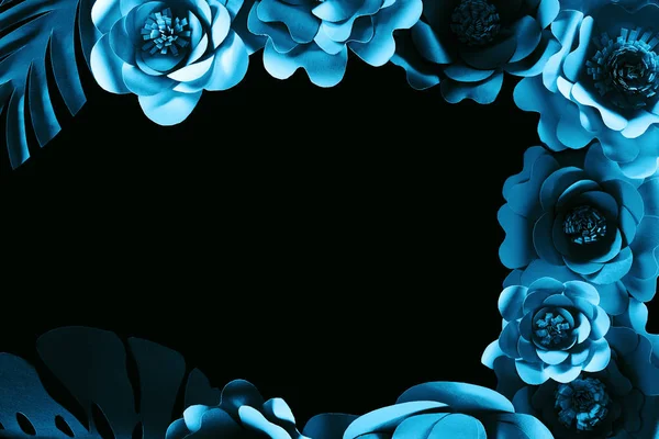 Vista superior de papel cortado flores azules aisladas en negro con espacio de copia - foto de stock
