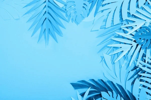 Cadre de feuilles de papier sur fond bleu minimaliste avec espace de copie — Photo de stock