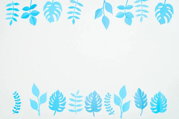 Top view of blue paper cut tropical leaves isolated on white with copy space — Stock Photo