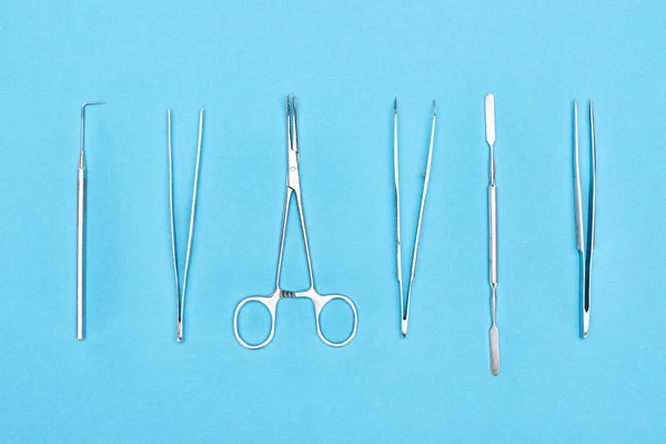 Top view of set with stainless dental tools isolated on blue — Stock Photo