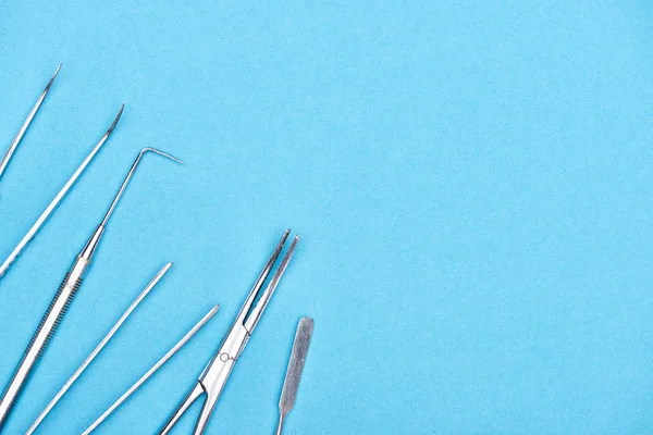 Top view of set with stainless dental instruments isolated on blue — Stock Photo