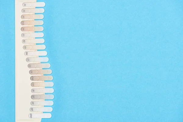 Vista dall'alto della tavolozza dei denti con diverse tonalità isolate sul blu — Foto stock