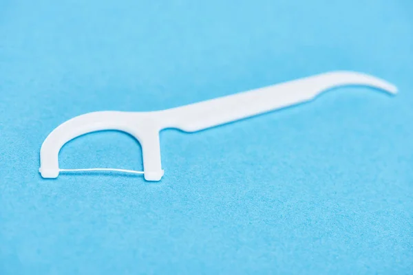 Selective focus of white floss stick isolated on blue — Stock Photo