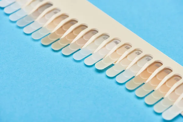 Enfoque selectivo de la paleta de dientes con diferentes tonos aislados en azul - foto de stock