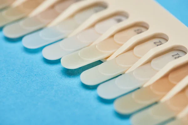 Selective focus of teeth palette with different shades on blue — Stock Photo