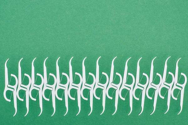 Tendido plano de palillos de dientes de hilo blanco aislados en verde - foto de stock