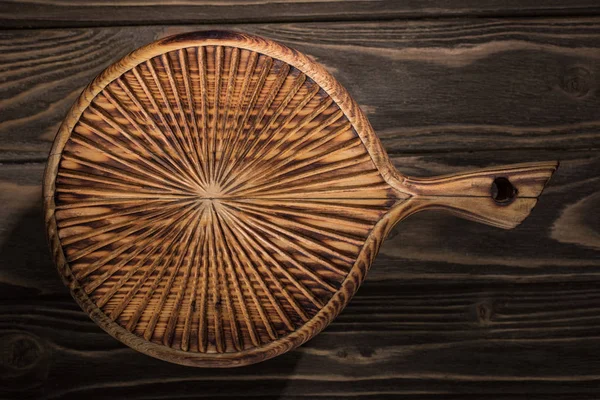 Top view of wooden cutting board on brown table — Stock Photo