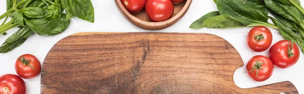 Plano panorámico de tabla de cortar de madera, verde y tomates cherry - foto de stock