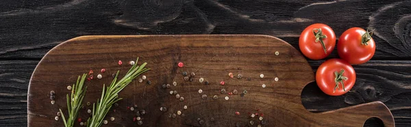 Plano panorámico de tabla de cortar de madera con especias, romero y tomates cherry - foto de stock