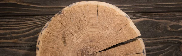 Panoramic shot of wooden cutting board on brown table — Stock Photo