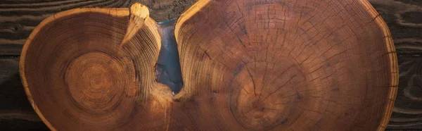 Panoramic shot of wooden cutting board on brown table — Stock Photo