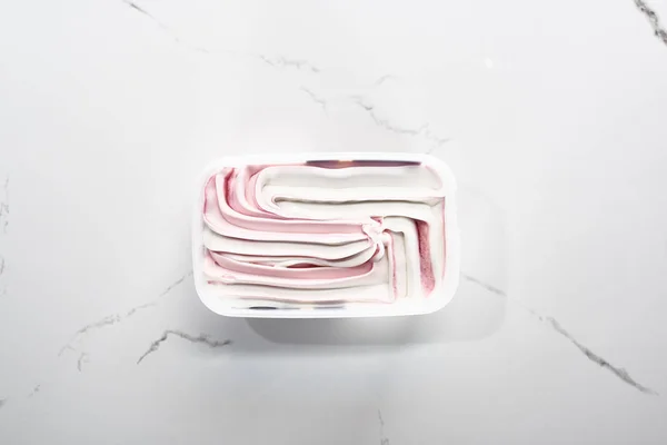 Draufsicht auf köstliches rosa und weißes Eis auf marmorgrauem Hintergrund — Stockfoto