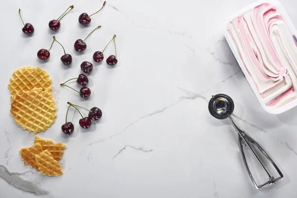 Vista superior de waffles deliciosos, colher e cerejas e sorvete no fundo cinza mármore — Fotografia de Stock