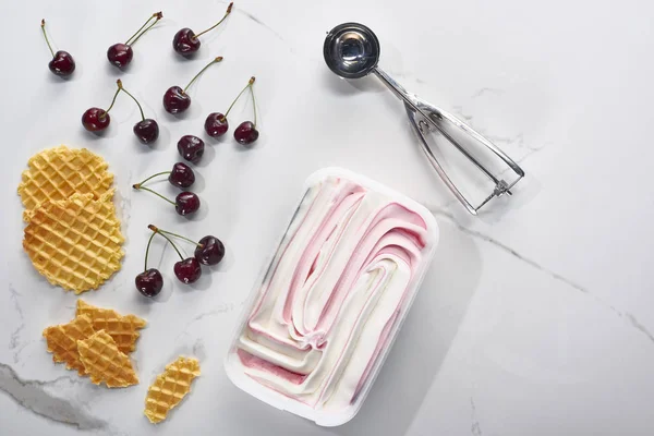 Vista dall'alto di cialde, cucchiai e ciliegie e gelato su fondo grigio marmo — Foto stock