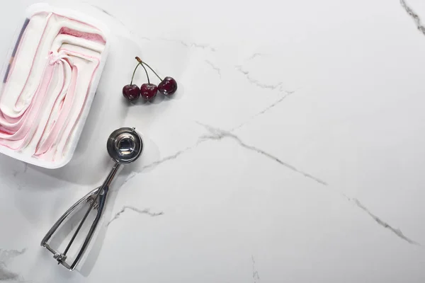 Vista dall'alto di deliziose ciliegie e gelato su sfondo grigio marmo con cucchiaio di gelato — Foto stock