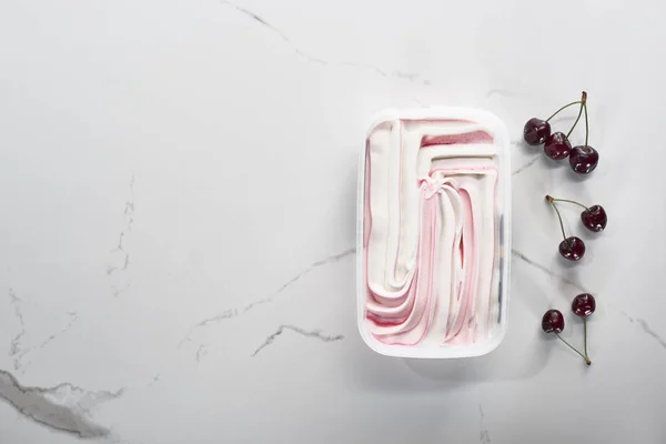 Draufsicht auf köstliches süßes Eis mit Kirschen auf marmorgrauem Hintergrund — Stockfoto