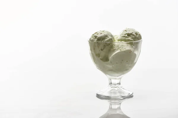 Delicious pistachio ice cream in glass bowl isolated on white — Stock Photo