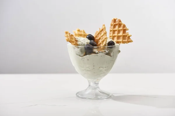 Delicious pistachio ice cream with waffles and blueberries isolated on grey — Stock Photo