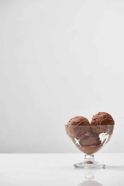 Delicioso helado de chocolate en cuenco de vidrio aislado en gris con espacio de copia — Stock Photo