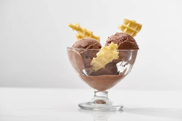 Delicioso helado de chocolate en tazón de vidrio con gofres aislados en gris - foto de stock