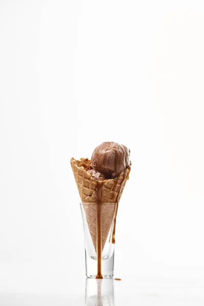 Delicioso sorvete de chocolate doce com chocolate derretido gotejamento em cone de waffle crocante isolado no branco — Fotografia de Stock