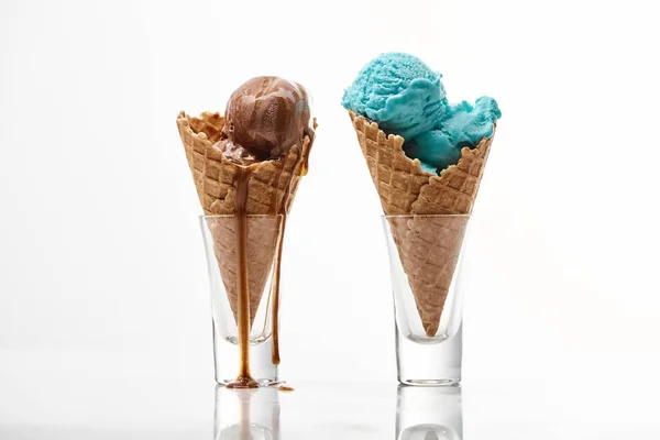 Délicieux chocolat sucré et crème glacée bleue dans des cônes de gaufre croustillants isolés sur blanc — Photo de stock