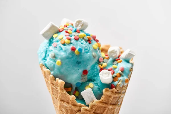 Vista da vicino di delizioso gelato blu dolce con marshmallow e spruzzi in cono cialda croccante isolato su grigio — Foto stock