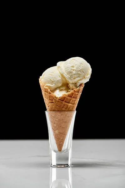 Delicious vanilla ice cream in crispy waffle cone isolated on black — Stock Photo