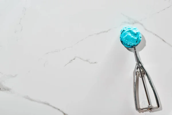 Вид на вкусное голубое мороженое в ложке мороженого на мраморном сером фоне — стоковое фото