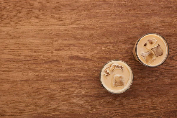 Vista dall'alto di delizioso caffè ghiacciato in bicchieri su tavolo di legno — Foto stock