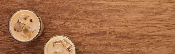 Vista dall'alto di caffè di ghiaccio in bicchieri su tavolo di legno, colpo panoramico — Foto stock