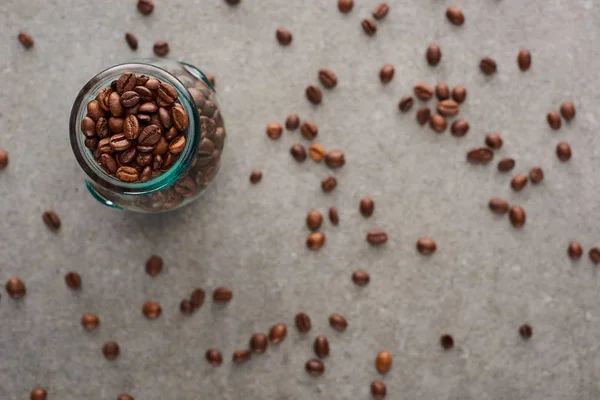 Selective focus of coffee grains in glass jar on grey background — Stock Photo