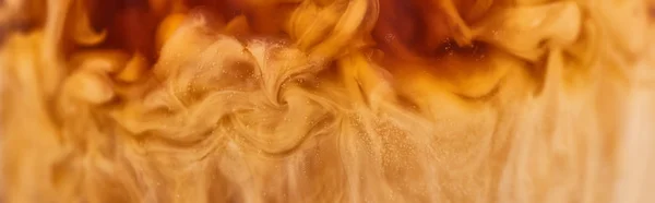 Close up view of brown coffee mixing with milk in glass, panoramic shot — Stock Photo