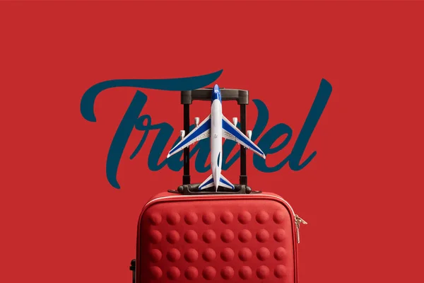 Rote bunt strukturierte Reisetasche mit Flugzeugmodell isoliert auf rot mit Reiseillustration — Stockfoto