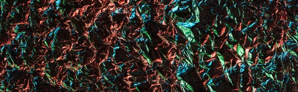 Panoramic shot of crumpled textured foil with colorful illumination — Stock Photo