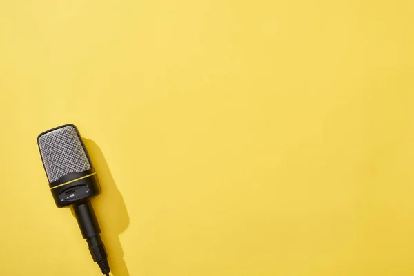 Top view of microphone on yellow background with copy space — Stock Photo