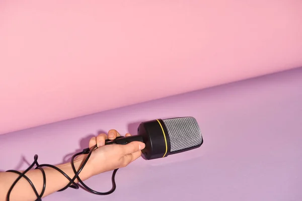 Cropped view of woman holding loudspeaker on colorful background — Stock Photo