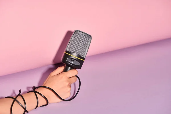 Cropped view of woman holding loudspeaker on colorful background — Stock Photo