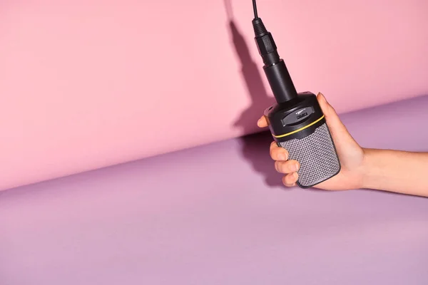 Cropped view of woman holding loudspeaker on colorful background — Stock Photo