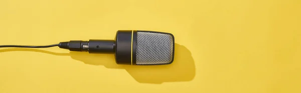 Panoramic shot of microphone on bright and colorful background — Stock Photo